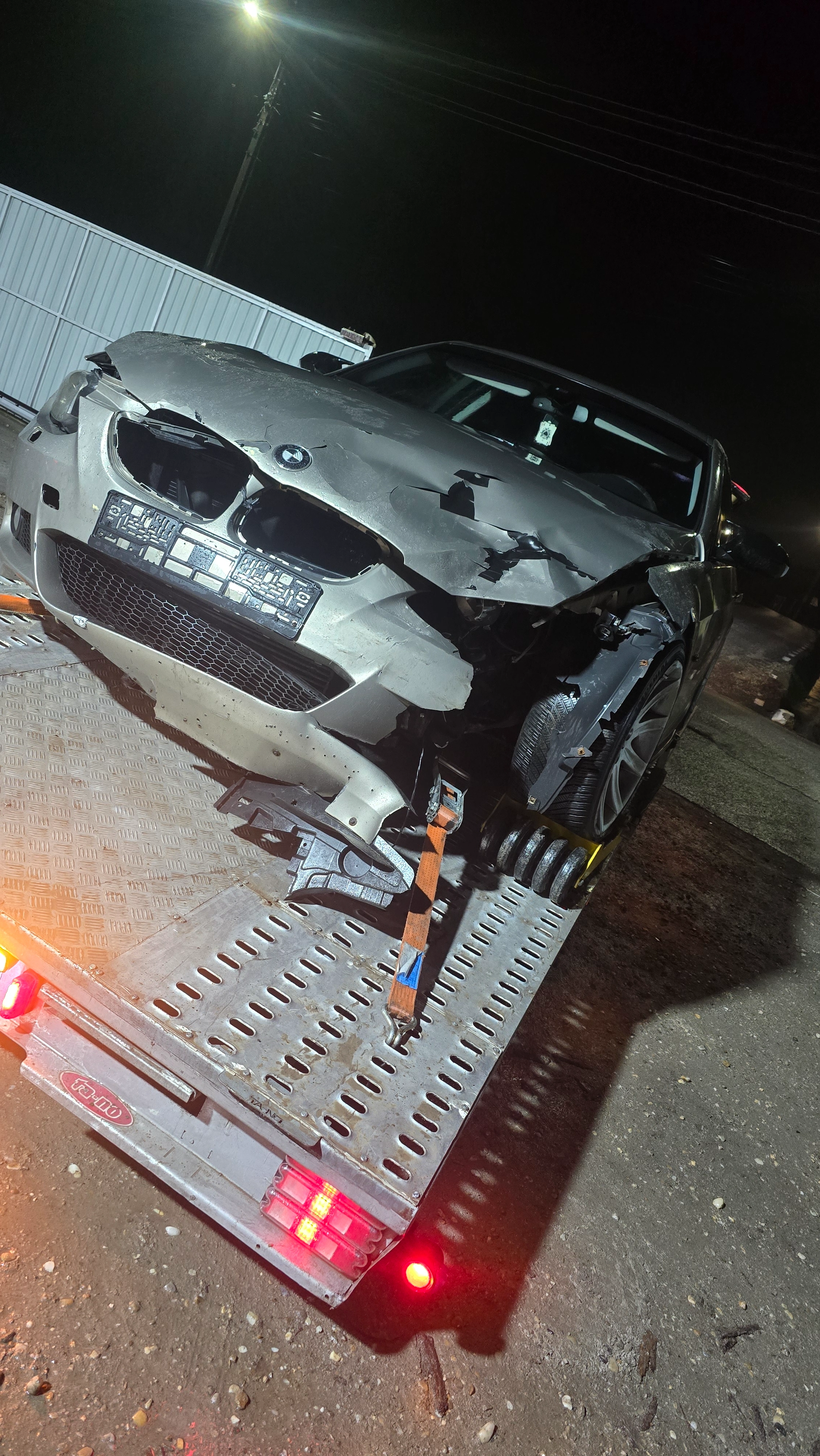 BMW avariat transportat pe platformă noaptea