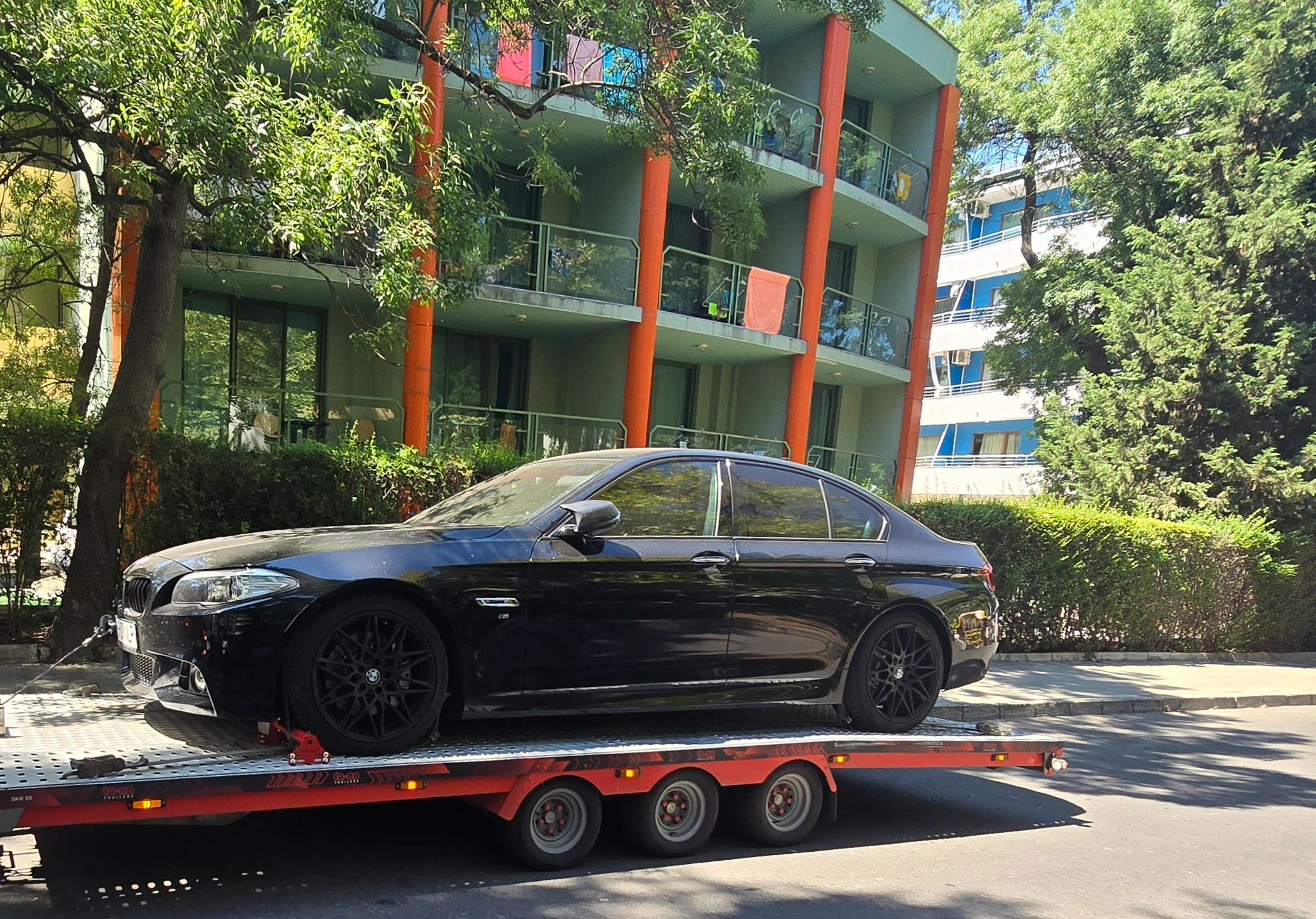 BMW Seria 5 negru transportat pe platformă
